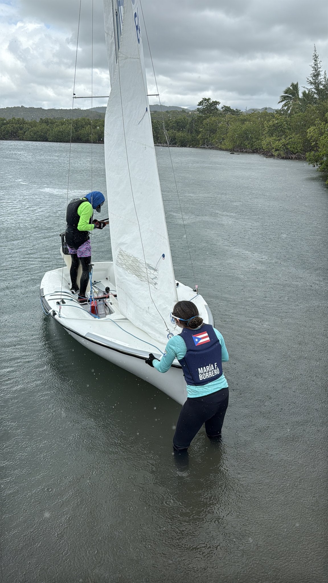 María launching her 420 dinghy in the mangroves